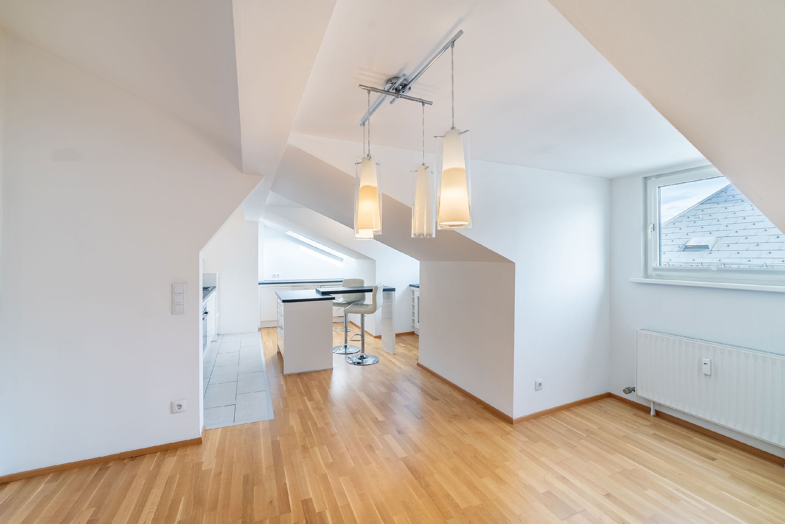 Im Wohnbereich mit charmanten Dachschrägen und der offenen Küche führt Sie eine Treppe auf die Dachterrasse, von welcher man einen "360°''-Blick über Salzburg genießt.
