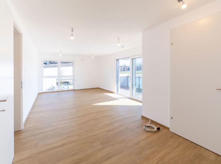 Ein besonderes Highlight ist der Wohn-/ Essbereich mit großflächigen Glasfronten und Zugang zum weitläufigen Balkon mit atemberaubendem Blick auf das vorgelagerte Grünland samt Gaisberg.